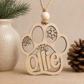 Personalized wooden dog paw Christmas ornament engraved with a pet's name and snowflake accents, handcrafted from Baltic birch.