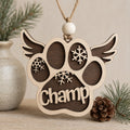Personalized wooden pet memorial ornament featuring a paw print with angel wings, snowflake accents, and a custom pet name, handcrafted from Baltic birch.