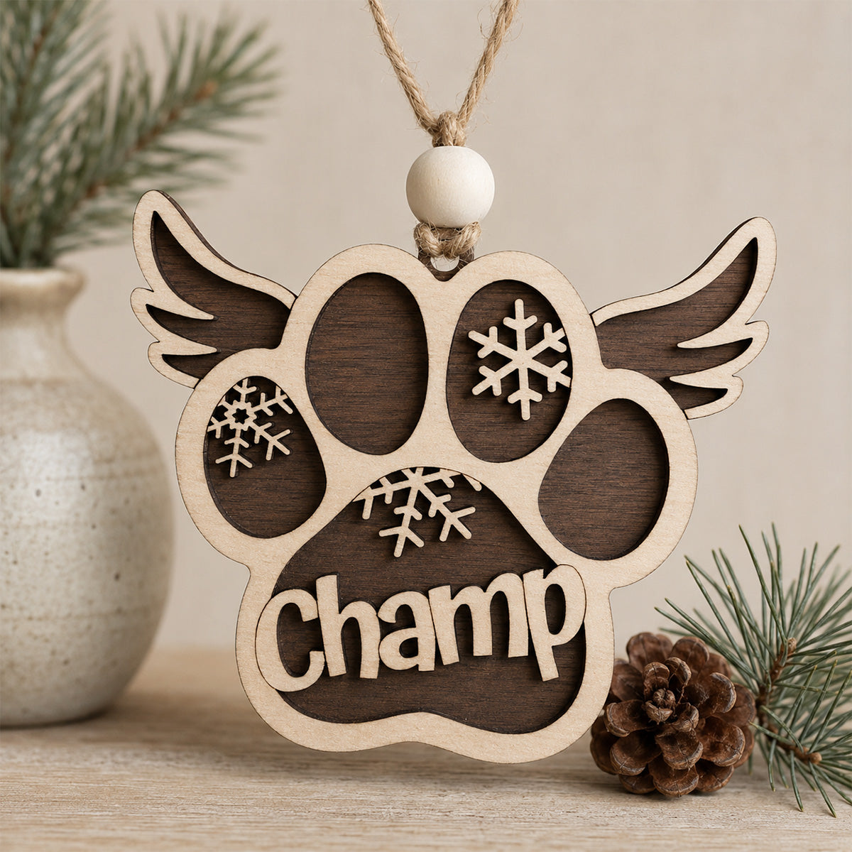 Personalized wooden pet memorial ornament featuring a paw print with angel wings, snowflake accents, and a custom pet name, handcrafted from Baltic birch.